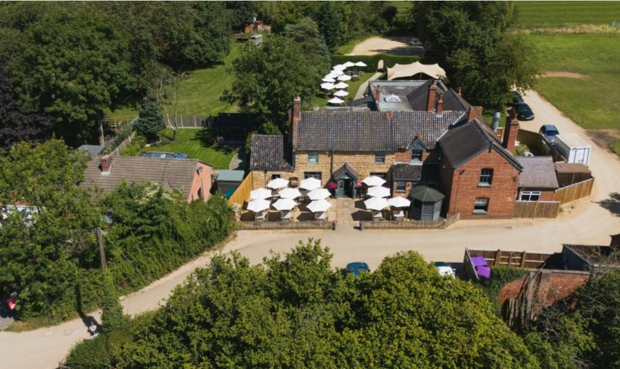 Aerial view of The Chequers and its gardens, surrounded by trees and fields